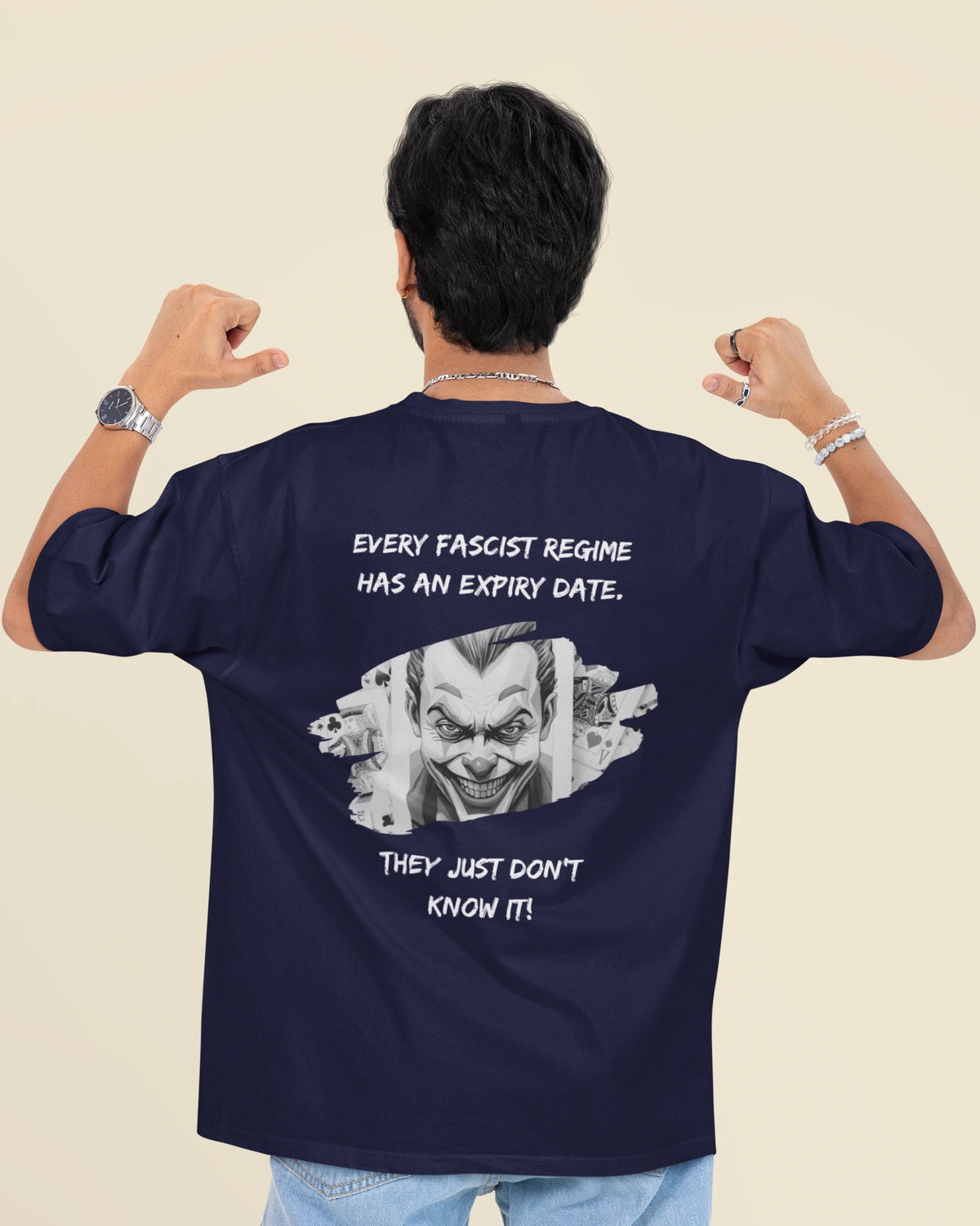 A man viewed from behind wearing a navy blue t-shirt with a white graphic of a clown face and the text 'EVERY FASCIST REGIME HAS AN EXPIRY DATE. THEY JUST DON'T KNOW IT!'.