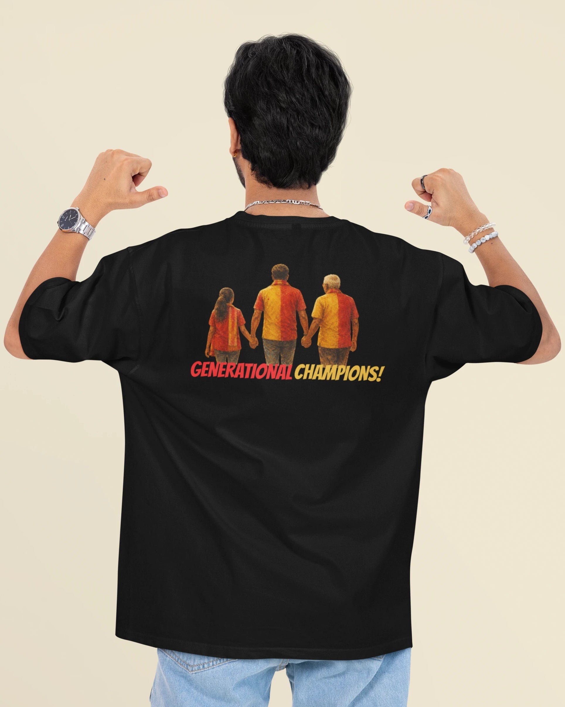 A man shown from behind wearing a black t-shirt with a graphic of three basketball players and the text 'GENERATIONAL CHAMPIONS!' in red and yellow. He is posing with his fists flexed against a solid beige background.