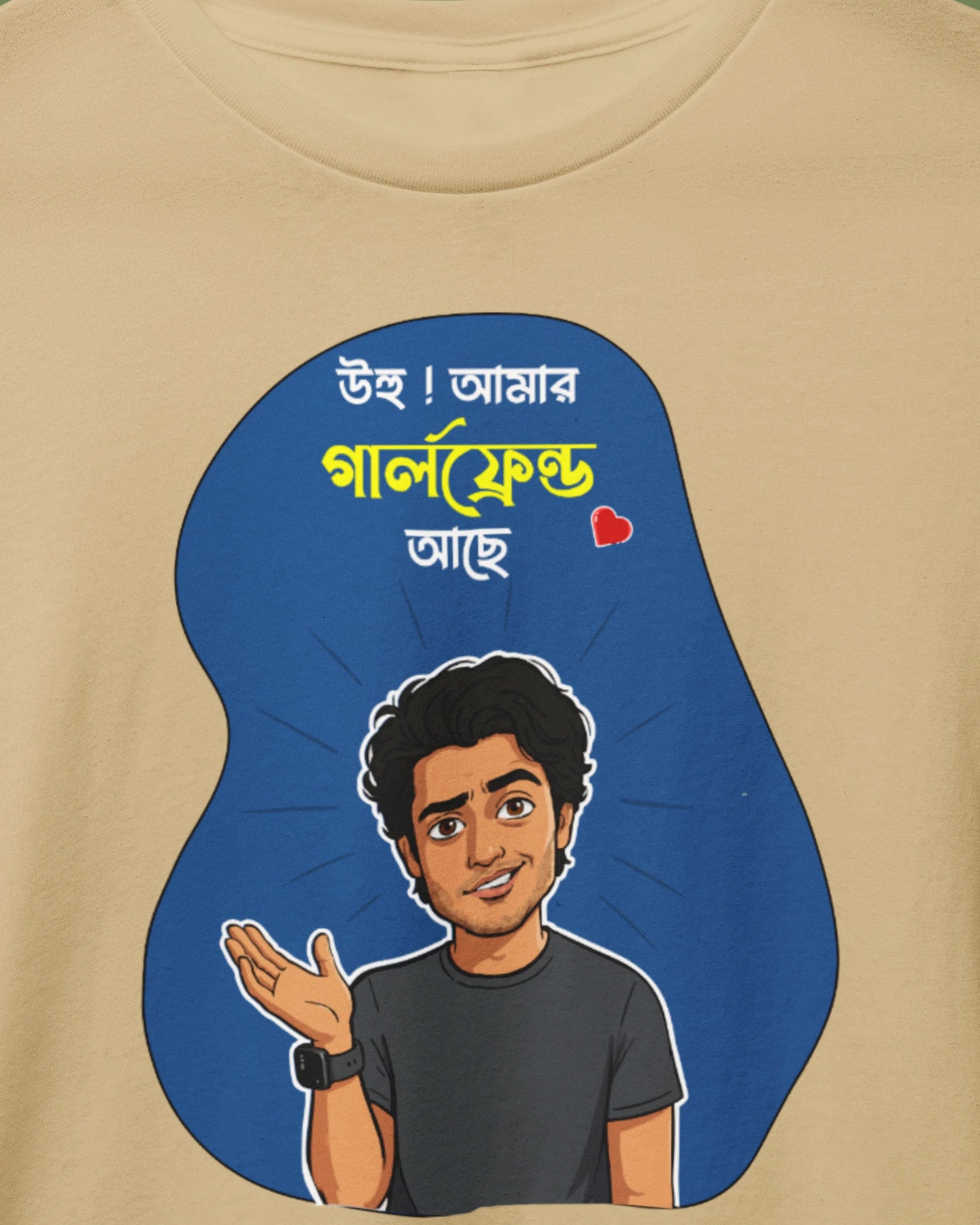 Beige crewneck t-shirt on a wooden hanger, featuring a cartoon illustration of a man with Bengali text on a blue abstract background graphic.