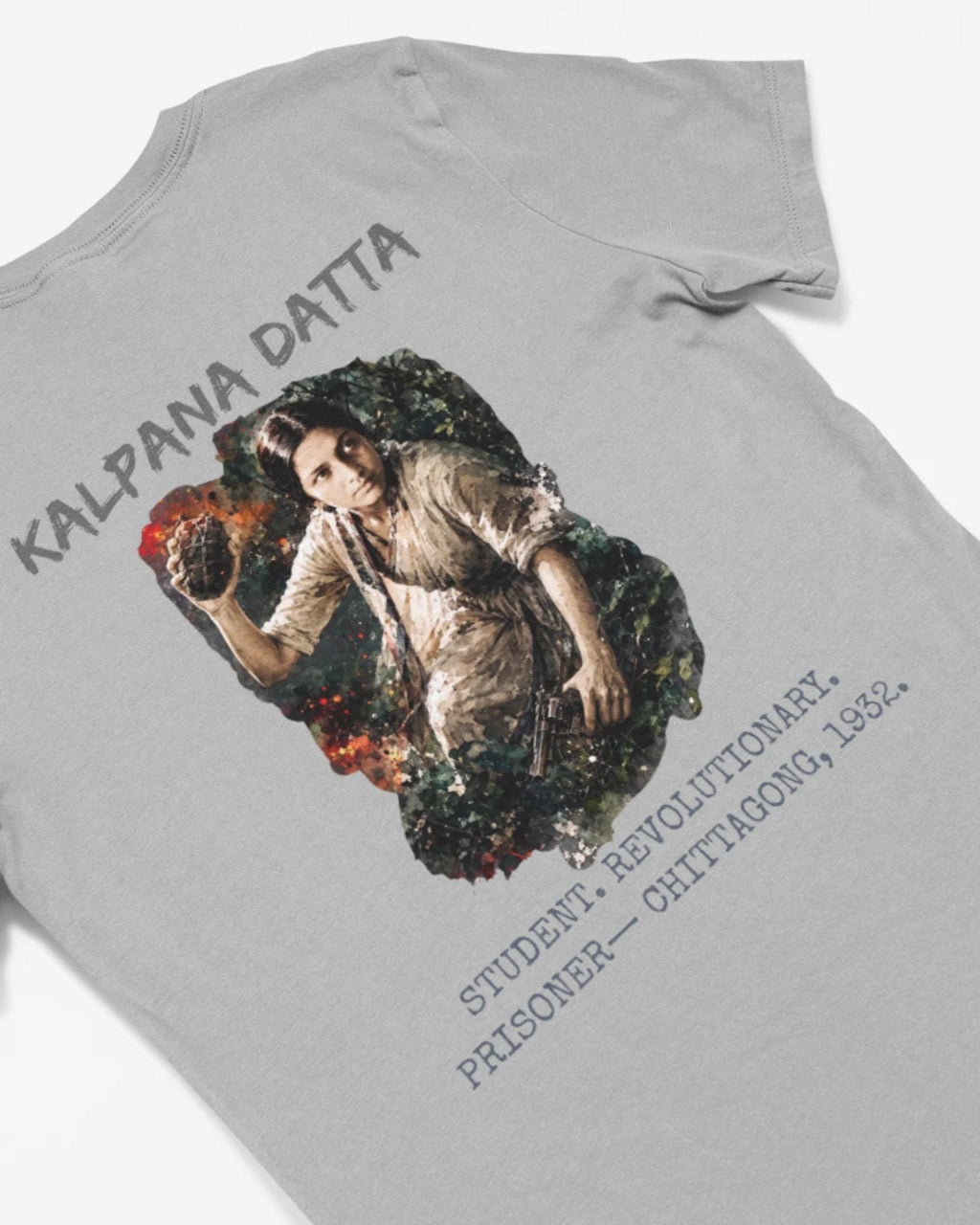 A light gray short-sleeve t-shirt laid flat on a white background, featuring a large graphic print on the back with the text 'KALPANA DATTA' and a vintage-style illustration of a woman.